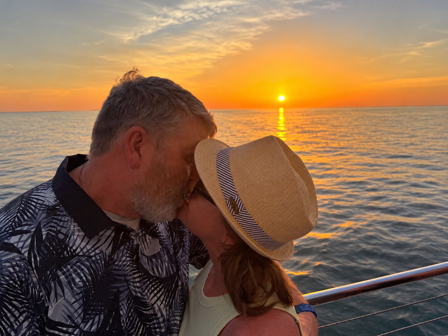 A couple sharing a quiet moment at sunset over the water.